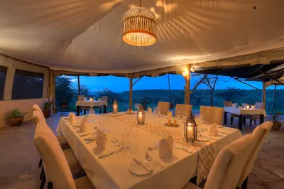 Dining tent set for dinner at dusk
