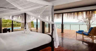 Canopy bed opening onto a sea-view deck