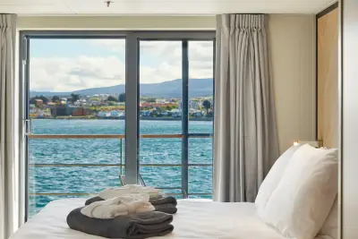 Deluxe Suite — bed facing balcony window