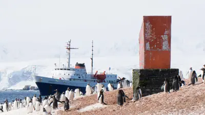 MV Ushuaia offshore from a penguin colony and refuge hut