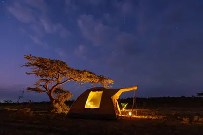 Wild-camp tent glowing at dusk