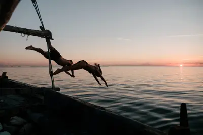Rope swing into the bay at sunset
