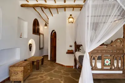 Suite four-poster bed with carved Swahili furniture