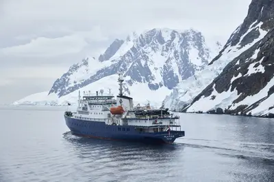 Plancius sailing below Antarctic peaks