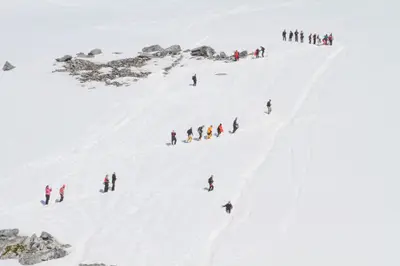 Guests hiking up a snow slope on a landing