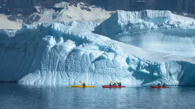 Sea kayaking beneath an iceberg